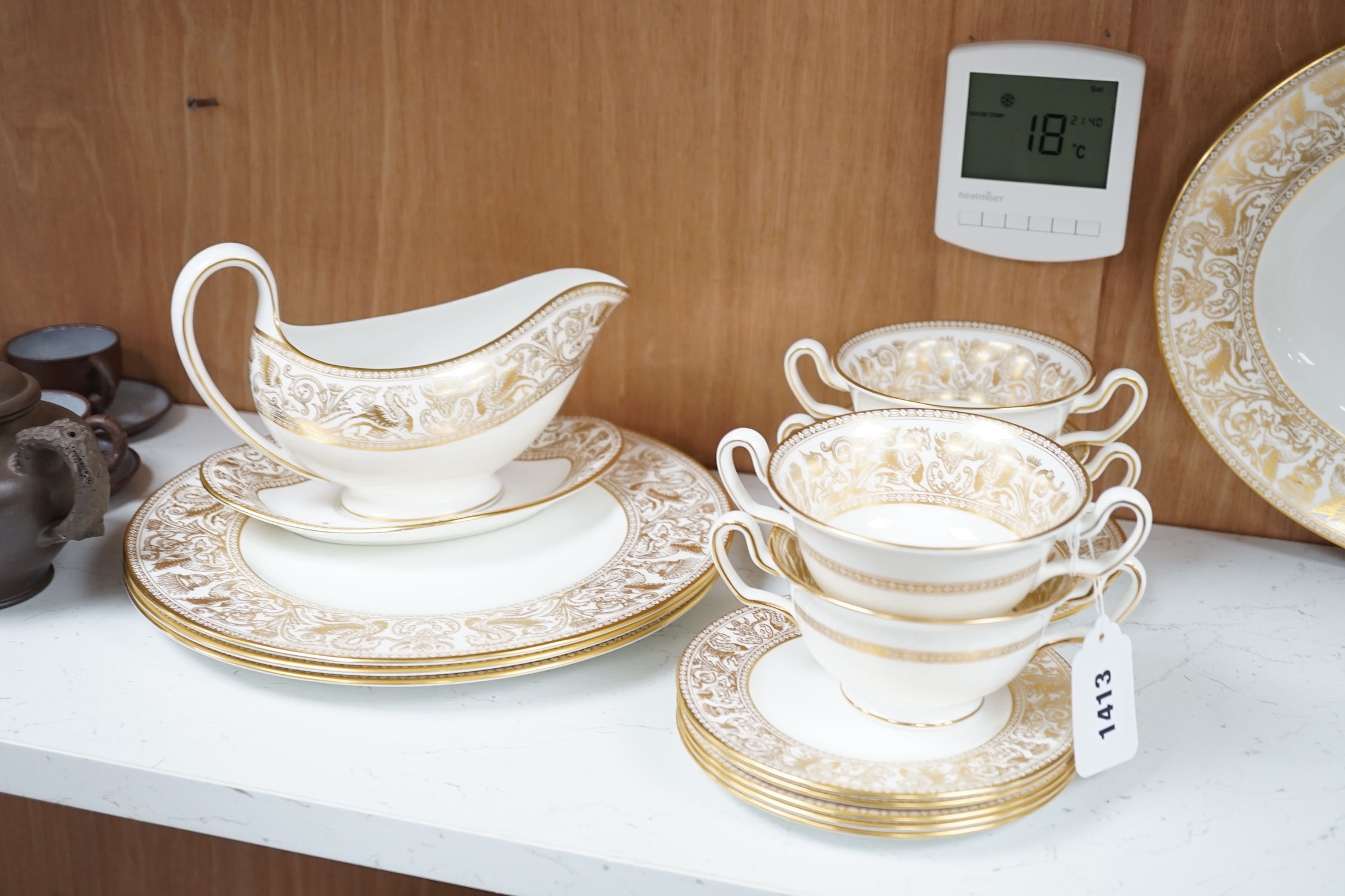 A Wedgwood bone china gold Florentine part dinner service, including an oval dish, twin handled cups and plates, largest 35cm wide